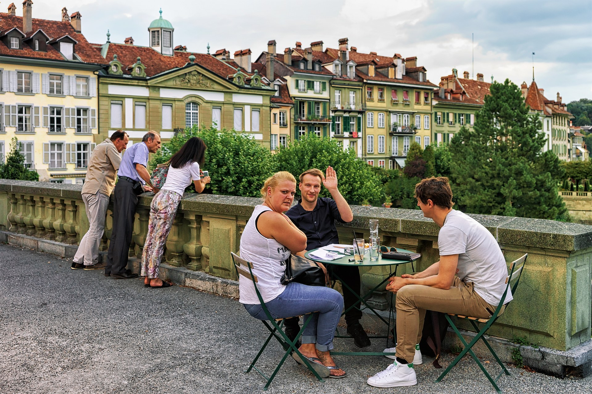 Přátelé u stolku venkovní kavárny na terase Münsterplattform v bernském Starém Městě